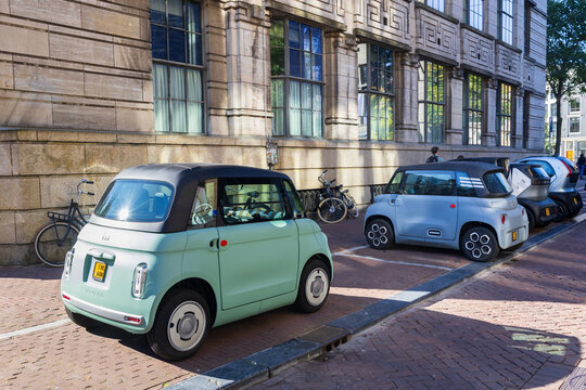 Amsterdam, The Netherlands, September 28, 2025 - Cute pale green tiny Fiat Topolino electric car parked next to other small cars in downtown street