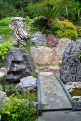 A bridge over a stream with beautiful boulders on a bright sunny day. Flora, nature, plants, landscape of parks.