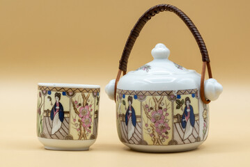 An elegant still life of a traditional Asian teacup and teapot set, showcasing intricate designs against a muted background