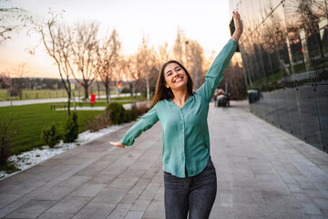Young woman enjoying freedom in the city with arms outstretched