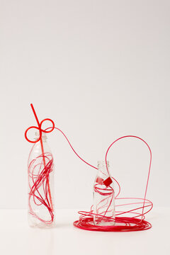 Glass and plastic bottles with red entangled wire art installation