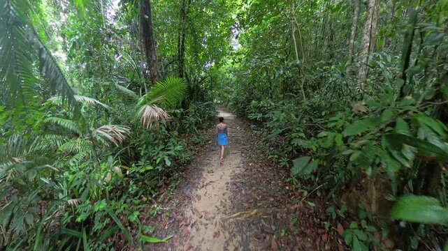 Malaysia, Redang Island: A girl blue dressed walking on the path in the middle of the jungle