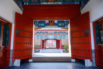 The open red gates of a traditional Chinese classical palace building.