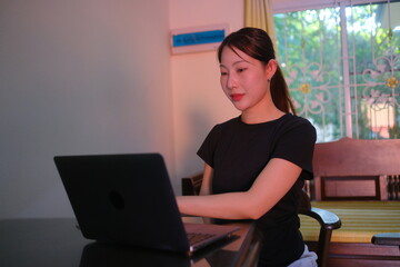A woman is sitting at a desk with a laptop in front of her
