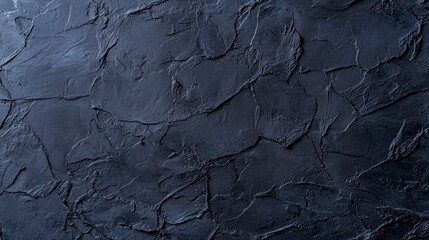 Textured dark stone surface with rough and smooth patches for artistic or design uses