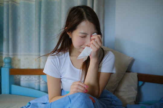 A woman is crying while holding a tissue