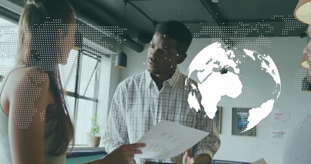 Analyzing printed charts man in checkered shirt presenting data in office, with world map overlay