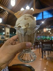 Woman holds a gelato in her left hand