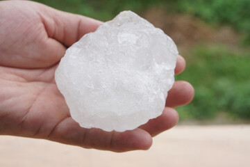 A hand holding a clear quartz crystal stone with natural texture. Symbol of purity, healing energy, and natural minerals. Suitable for concepts of nature, balance, and wellness.