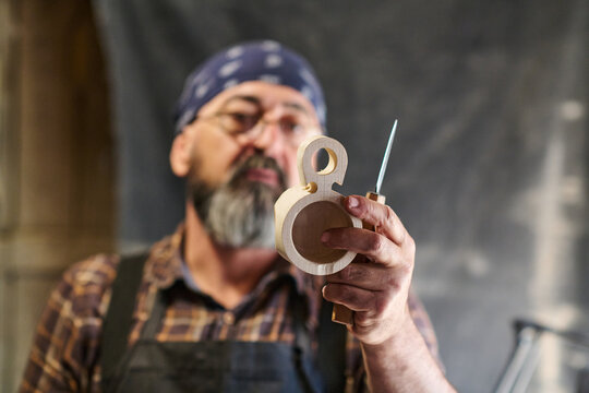 Woodworker crafting wooden cup with knife, focused on the detail, artisan at work, handmade product, carving process, traditional craft, workshop setting, skilled craftsman, hobby project.