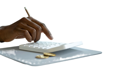 A dark-skinned hand uses a calculator with two coins on a surface, on a black backdrop