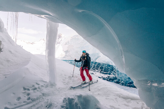 A group of skiers explore the large ice caves in the Northern Rockies of British Columbia, Canada.