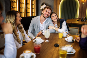 Couple hugging at restaurant with friends