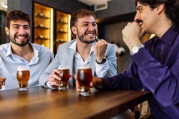Three men enjoying beer and conversation in pub