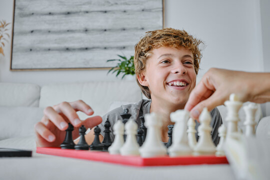 Teenager enjoying a chess game at home setting