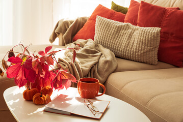 Cozy Autumn Living Room Scene with Mug, Notebook and Seasonal Decor under Sun Light