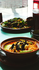 Mesa con comida mexicana servida al mediodía: sopa de tortilla, ensalada, bebidas y cerveza artesanal. Iluminación natural que resalta el ambiente relajado