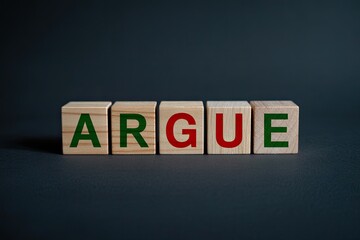 Obraz premium Wooden blocks spelling argue concept communication conflict disagreement dispute debate discussion conflict resolution creative idea