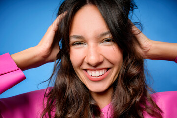 Young woman smiling with vibrant blue background