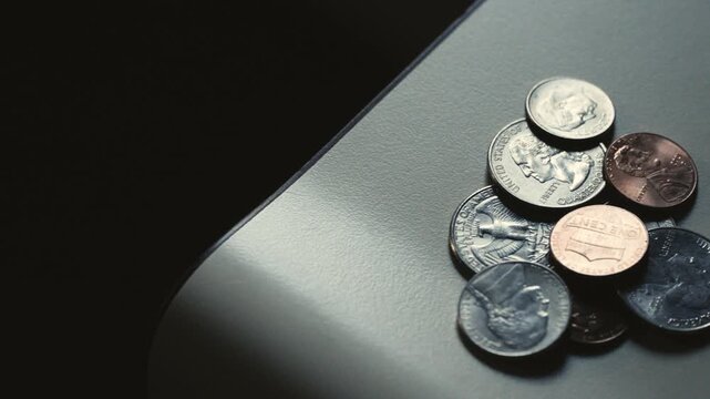 Stack of American coins and currency on the edge of a countertop