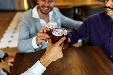 Three men cheering with beer