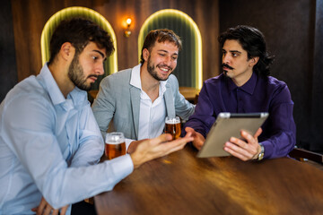 Colleagues discussing work over beer in restaurant