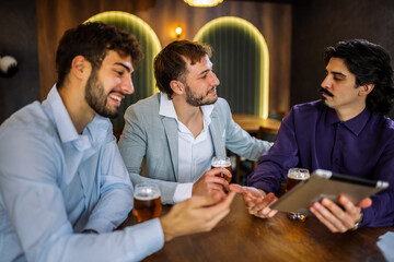 Colleagues discussing work over beer in restaurant