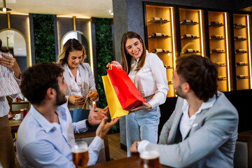 Women surprise men after shopping in restaurant