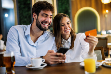 Couple shopping online in restaurant