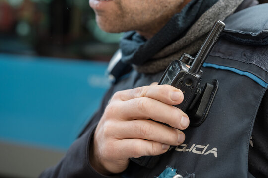 Police officer holding radio transceiver during patrol