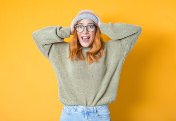 Astonished happy girl with hands on his head, isolated on yellow background. Positive news....