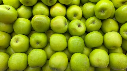 Fresh green apples piled together, perfect for healthy living, organic food themes, grocery ads, natural produce, and clean eating concepts.