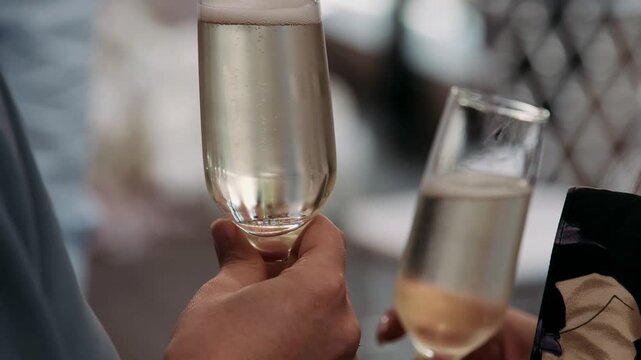 People with glasses in their hands chatting at a buffet reception.  Link &times;Title:
Celebration, champagne and toast with people clinking glasses at sunset for party, friendship and happy moment on rooft