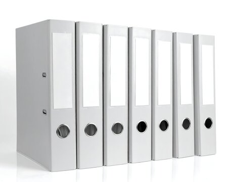 Close-up of neatly arranged white office binders with blank label space
