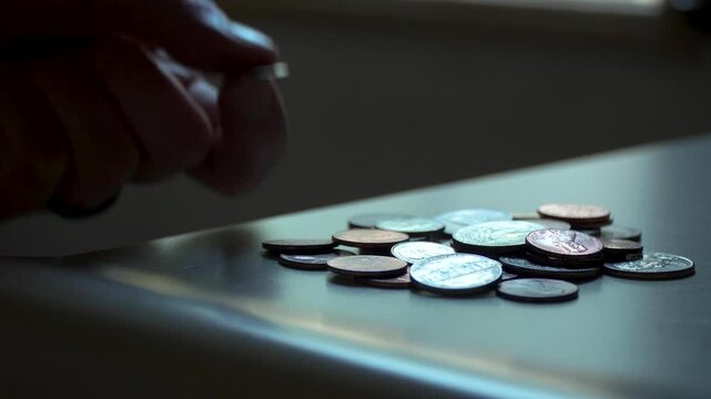 Close-up of a man taking coins off of a kitchen counter