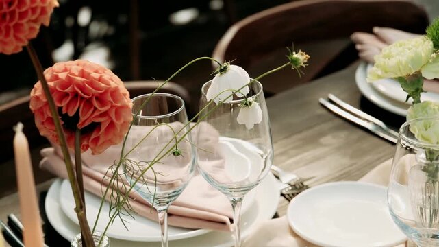The wedding banquet tables are decorated with flowers and set with plates and glasses.