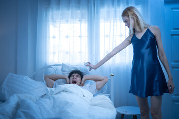 A playful woman shows off her alarm clock to remind her partner