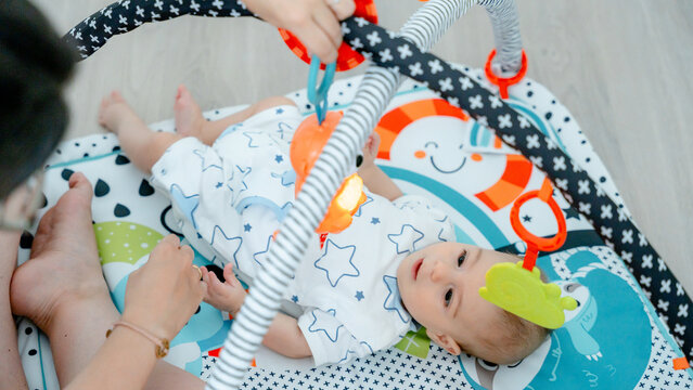 Baby on colorful playmat enjoying developmental activity