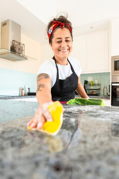 Woman cleaning kitchen countertop after baking bread
