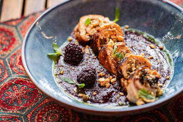 Chicken rolls with blackberry sauce and mint garnish
