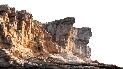 Dramatic rocky cliff face illuminated by golden sunlight against a dark sky