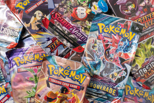 Bradford, UK Oct 30 2025 - A collection of vibrant metallic pok&eacute;mon trading card game booster packs arranged over each other.