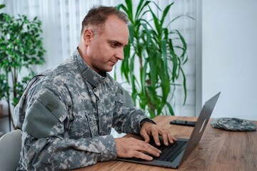American soldier working on laptop at home