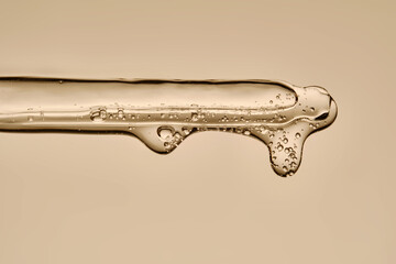 The texture of the hyaluronic serum flowing down the dropper.