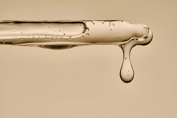 The texture of the hyaluronic serum flowing down the dropper.