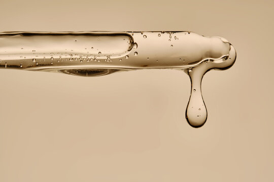 The texture of the hyaluronic serum flowing down the dropper.