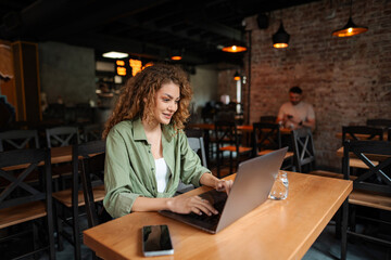 Young woman working on laptop in a restaurant