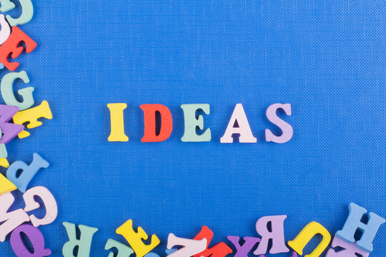 IDEAS word on blue background composed from colorful abc alphabet block wooden letters, copy space for ad text. Learning english concept.