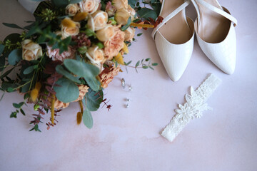 Rings, earrings, bouquet, bridal shoe