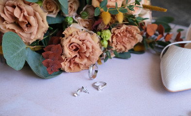 Rings, earrings, bouquet, bridal shoe